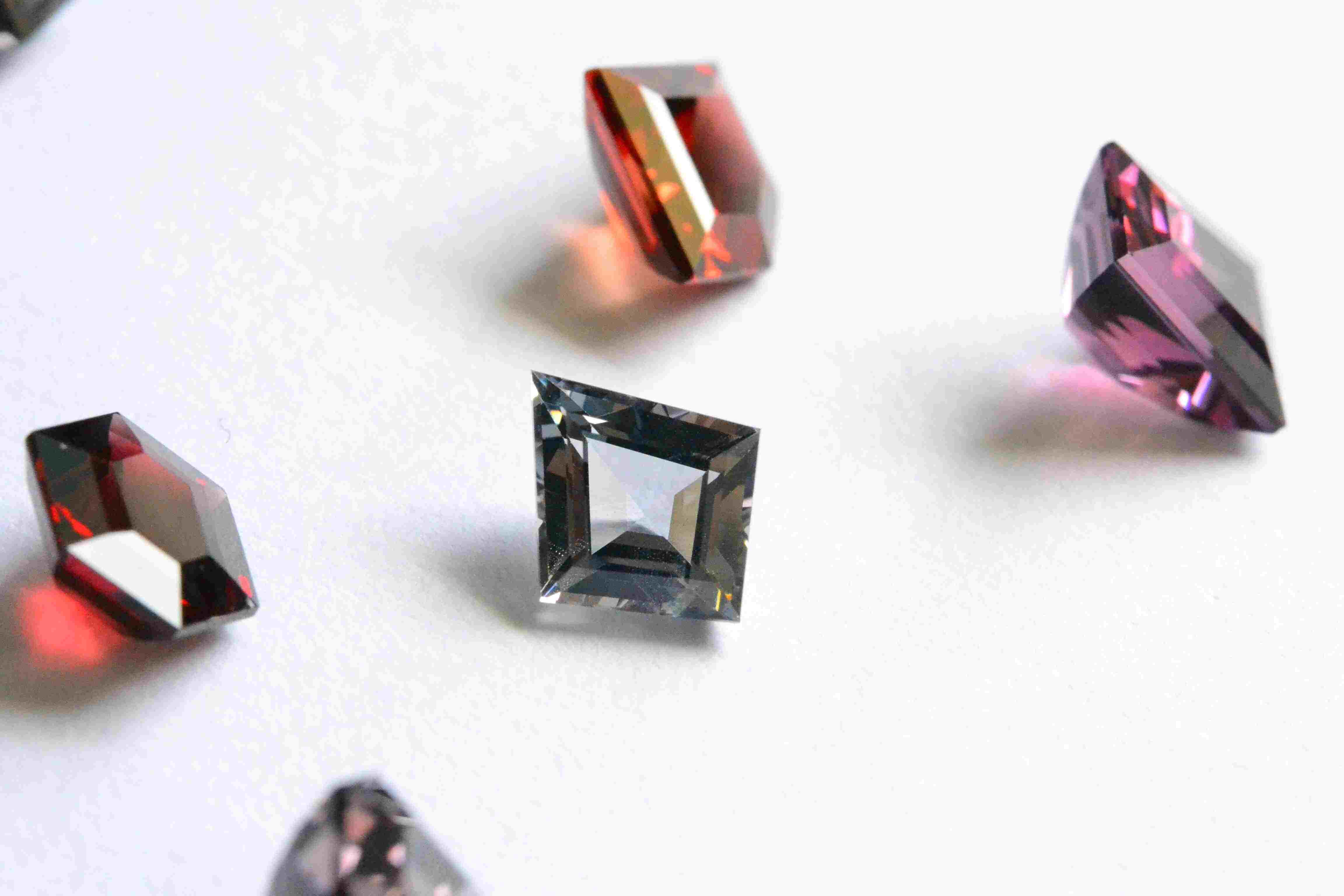 A fancy cut (kite) Burmese grey spinel, amongst a Burmese spinel lot.